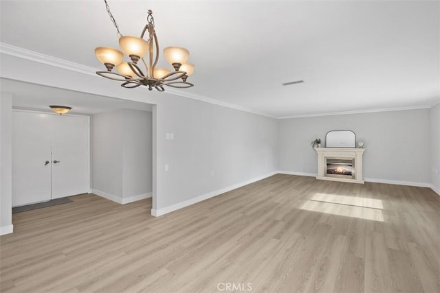 unfurnished living room with crown molding, light wood-type flooring, and a chandelier