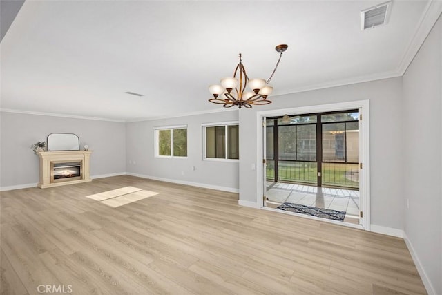 unfurnished living room featuring an inviting chandelier, crown molding, and light hardwood / wood-style floors