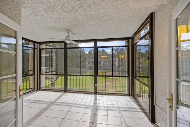 unfurnished sunroom with ceiling fan