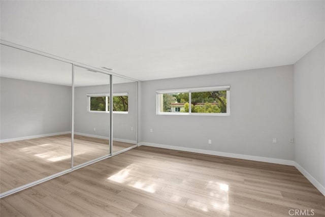 unfurnished bedroom with a closet and light wood-type flooring