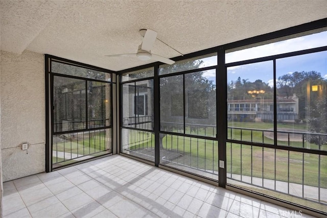 unfurnished sunroom featuring ceiling fan