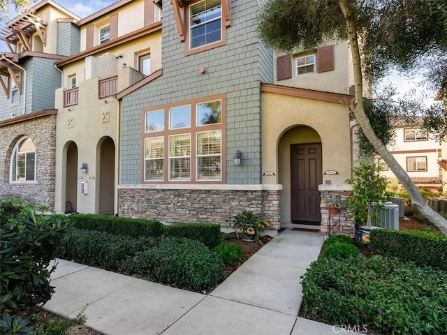 exterior space featuring stone siding and stucco siding