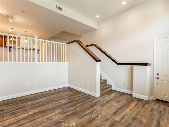 spare room with recessed lighting, wood finished floors, visible vents, baseboards, and stairway