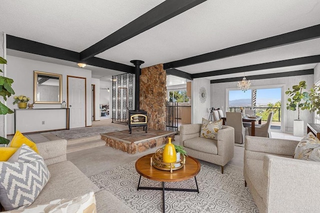 living room with beam ceiling, a textured ceiling, a chandelier, and a wood stove