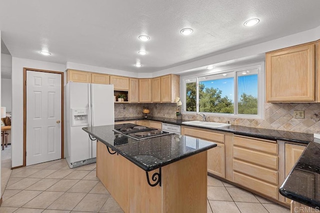 kitchen with sink, dark stone counters, a center island, light tile patterned floors, and white appliances