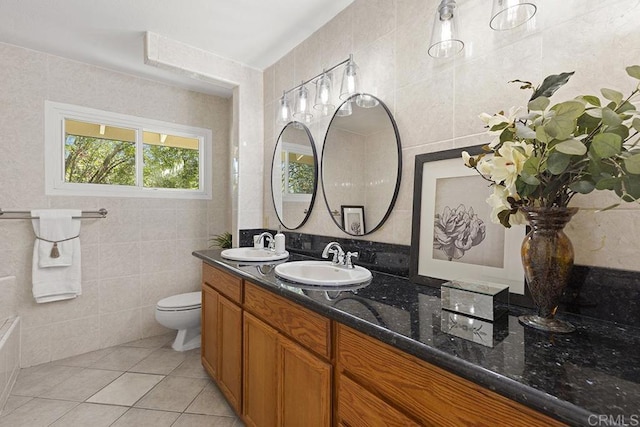 bathroom featuring vanity, toilet, tile patterned flooring, and tile walls