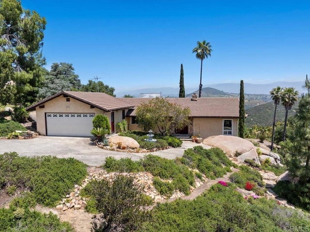 single story home featuring a garage and a mountain view