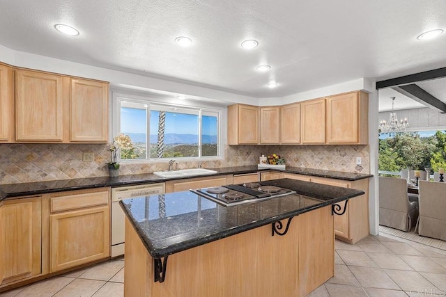 kitchen with stainless steel gas stovetop, a center island, dishwasher, and dark stone countertops