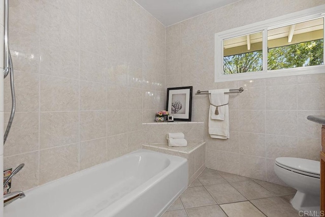 bathroom featuring tile walls, tile patterned flooring, a tub, and toilet