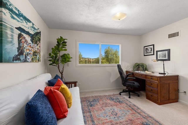 home office with light colored carpet and a textured ceiling