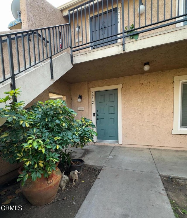 view of exterior entry with a balcony