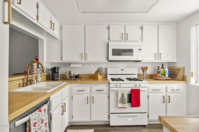 kitchen with sink, white appliances, dark wood-type flooring, and white cabinets