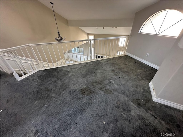 interior space with vaulted ceiling and dark colored carpet