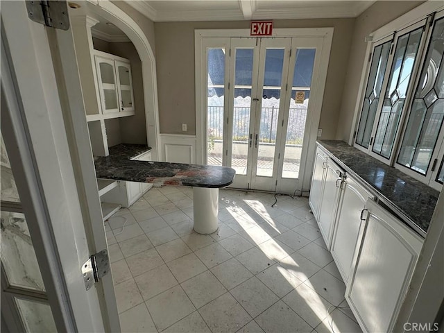 doorway with french doors, crown molding, and light tile patterned floors