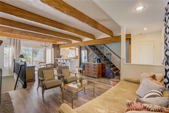 living room with hardwood / wood-style flooring, beam ceiling, and a notable chandelier