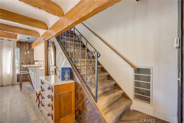 stairs with beam ceiling and wood-type flooring