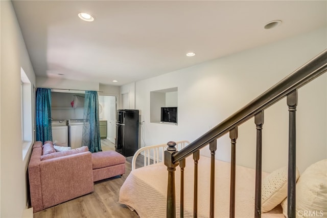 living room featuring independent washer and dryer and light hardwood / wood-style floors