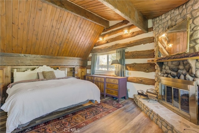 bedroom featuring lofted ceiling with beams, hardwood / wood-style flooring, wooden ceiling, and log walls