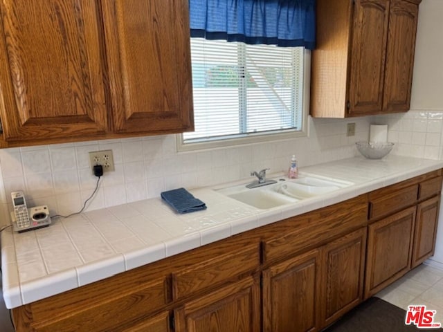 kitchen featuring tasteful backsplash, sink, and tile counters