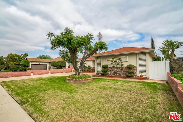 single story home featuring a garage and a front yard