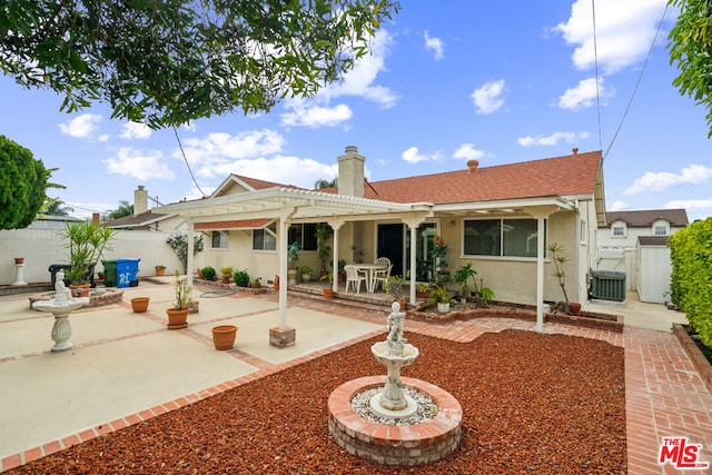 rear view of house with a pergola, a patio area, and central AC