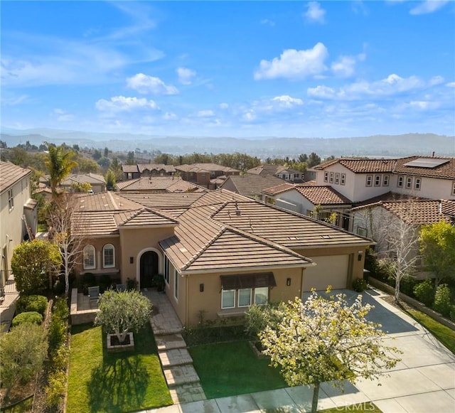 view of front of house featuring a garage, a mountain view, and a front yard