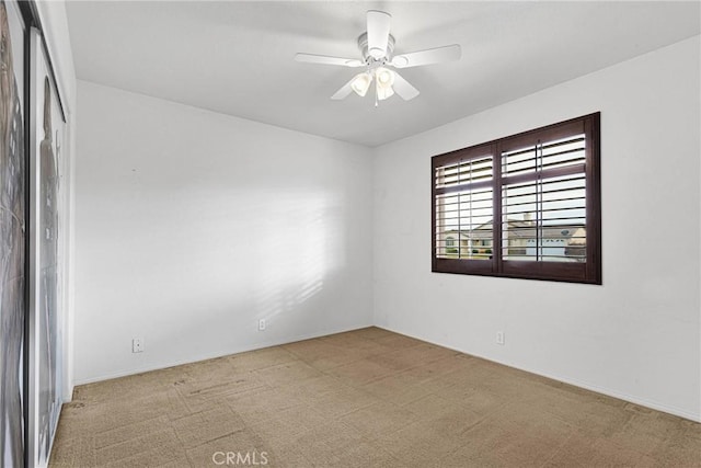 empty room featuring ceiling fan and light carpet