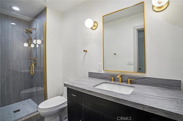 bathroom featuring vanity, toilet, and a shower with shower door