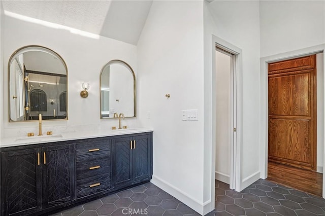 bathroom featuring tile patterned floors, lofted ceiling, and vanity