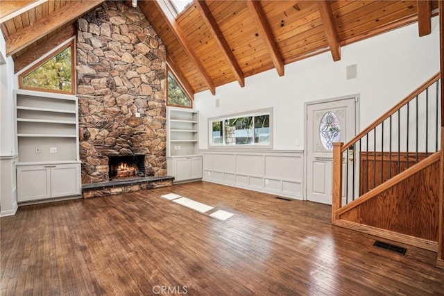 unfurnished living room with beam ceiling, a fireplace, wooden ceiling, and dark hardwood / wood-style floors