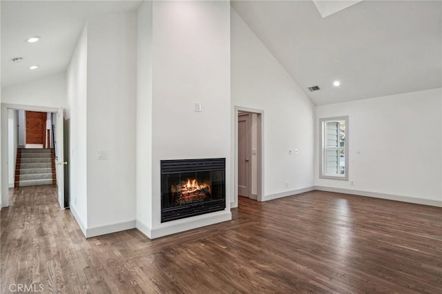 unfurnished living room with hardwood / wood-style flooring and high vaulted ceiling