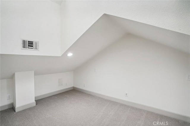 additional living space with vaulted ceiling and light carpet