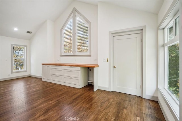 bonus room featuring lofted ceiling, dark wood-type flooring, and built in desk