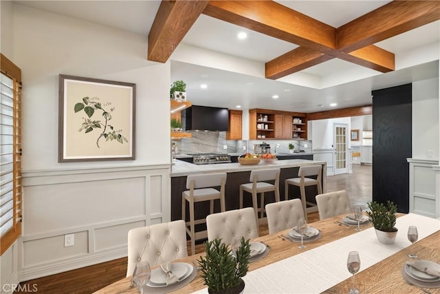 dining space featuring coffered ceiling, hardwood / wood-style floors, and beamed ceiling