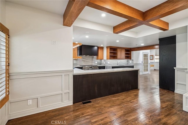 kitchen with high end stove, tasteful backsplash, dark hardwood / wood-style flooring, kitchen peninsula, and beam ceiling