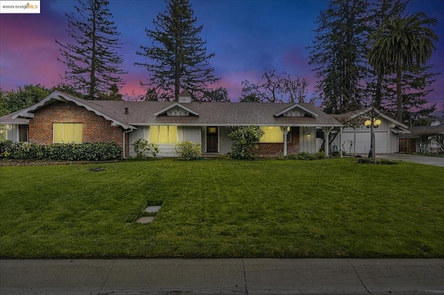 single story home featuring a garage and a yard