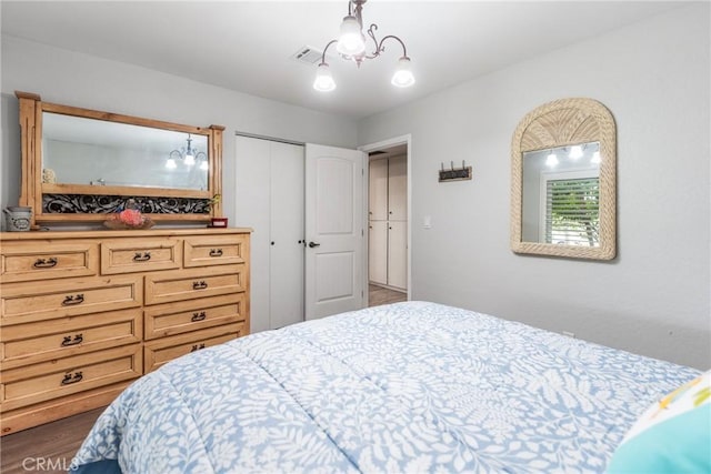 bedroom featuring dark hardwood / wood-style floors, a chandelier, and a closet