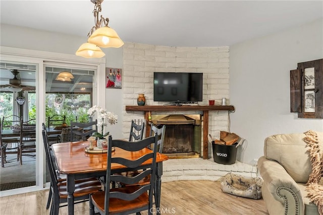 dining area with hardwood / wood-style flooring and a fireplace