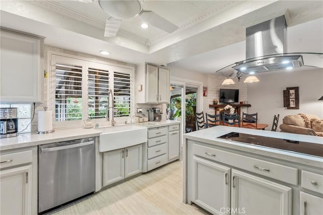 kitchen with sink, a tray ceiling, dishwasher, island exhaust hood, and black electric stovetop