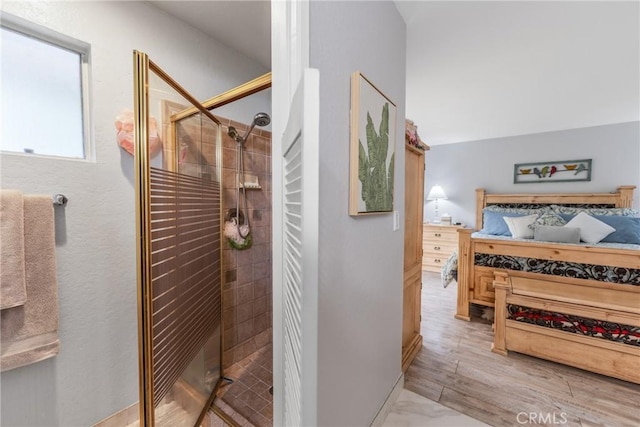 bathroom with hardwood / wood-style flooring and an enclosed shower