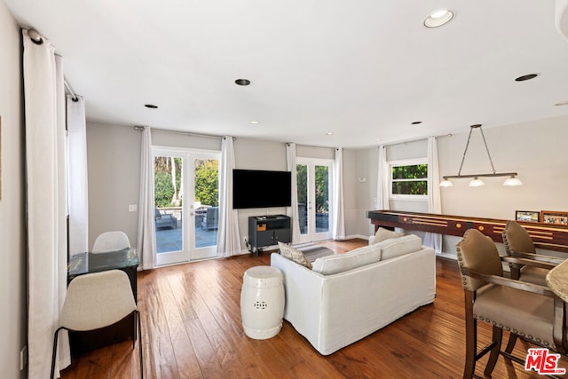 living room featuring a healthy amount of sunlight, hardwood / wood-style floors, and french doors