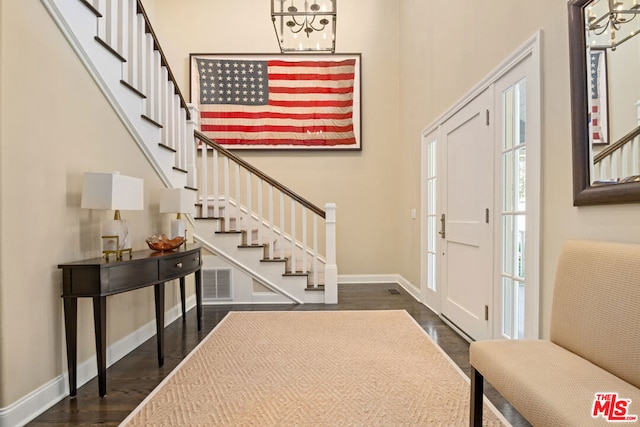 entrance foyer with a towering ceiling and dark hardwood / wood-style flooring