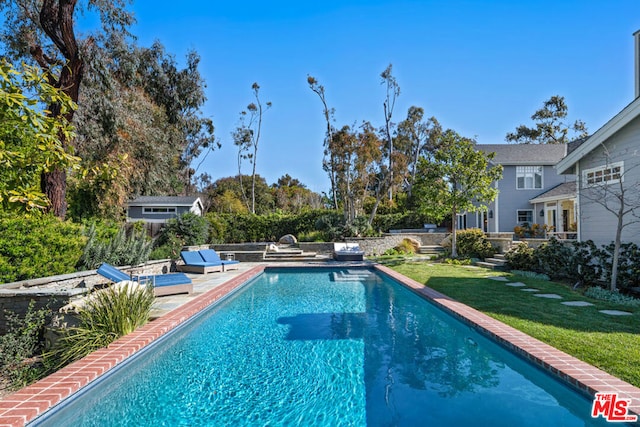 view of pool with a yard