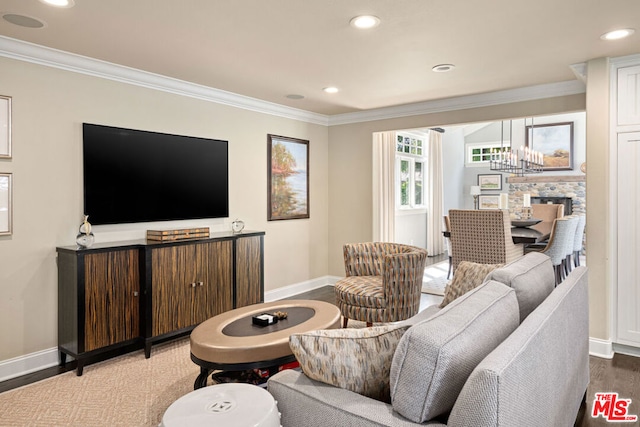 living room with ornamental molding, wood-type flooring, and an inviting chandelier