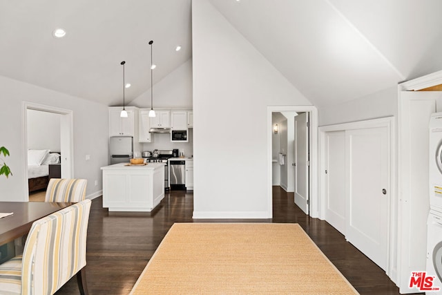 dining space featuring stacked washer / dryer, high vaulted ceiling, and dark hardwood / wood-style flooring