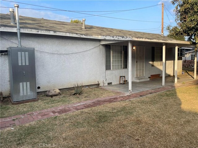 rear view of property with a patio area and a lawn