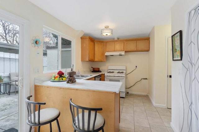 kitchen featuring sink, light tile patterned floors, kitchen peninsula, dishwasher, and white gas range oven