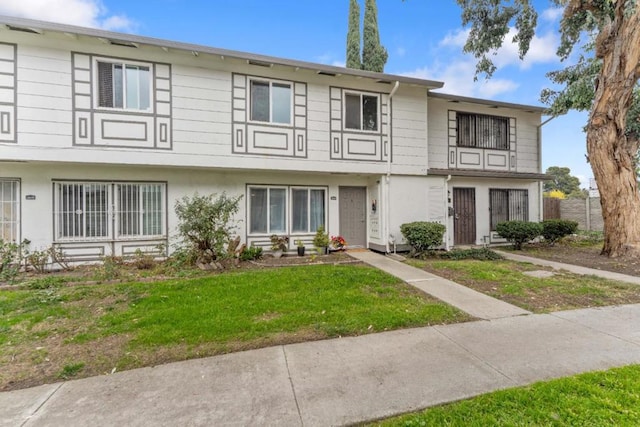 townhome / multi-family property featuring a front yard