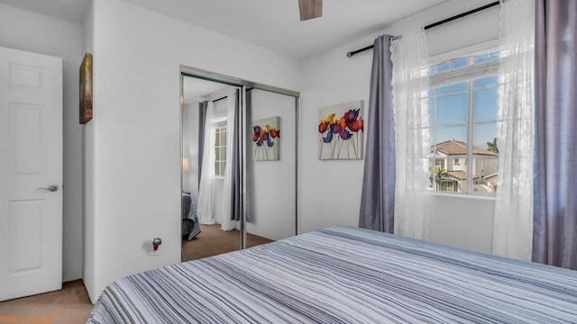 carpeted bedroom featuring ceiling fan and a closet