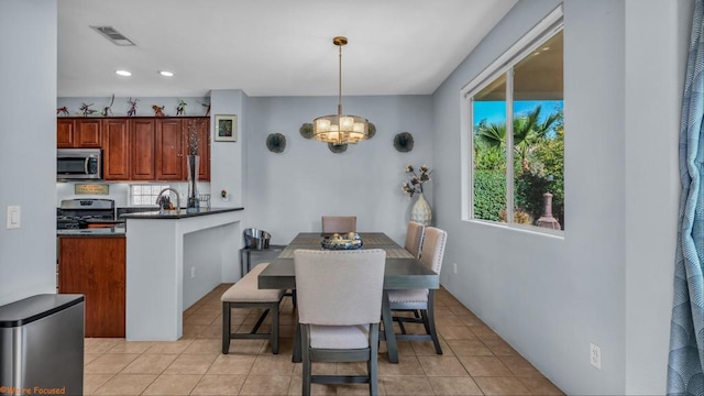 tiled dining area featuring an inviting chandelier